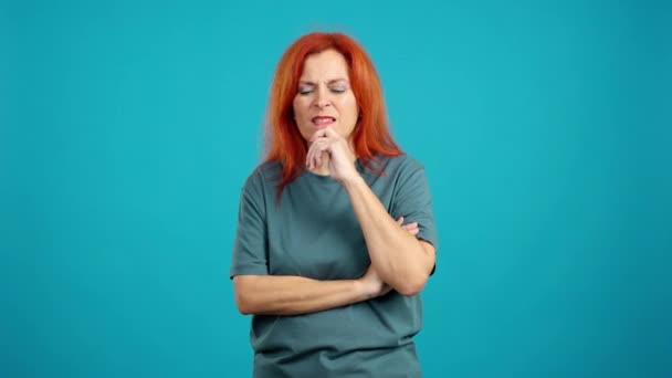 Redheaded Mature Woman Hand Face Thoughtful Expression Studio Blue Background — Stock Video