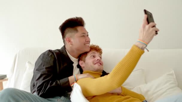 一对温柔体贴的同性恋夫妇躺在沙发上自拍的慢镜头 — 图库视频影像