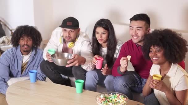 Filmik Grupą Przyjaciół Oglądających Telewizję Jedzącą Popcorn Frytki — Wideo stockowe