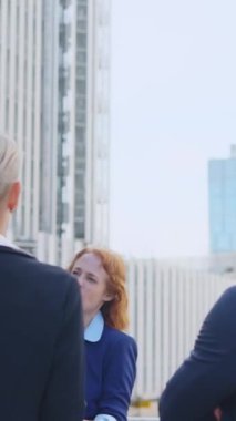 Yetişkin kızıl saçlı bir iş kadınının sokakta duran çalışanlarından daha fazla çaba istediği yavaş çekim videosu.