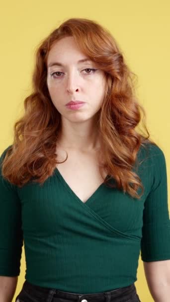 Redheaded Γυναίκα Κοιτάζοντας Κάμερα Μια Θυμωμένη Έκφραση Στο Στούντιο Κίτρινο — Αρχείο Βίντεο