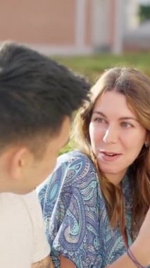 Chinese man and a caucasian woman talking in the street among a group of friends