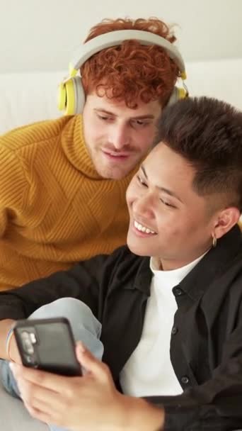 Eşcinsel Partnerin Evdeki Koltukta Dinlemesi Için Cep Telefonunda Şarkı Çalan — Stok video