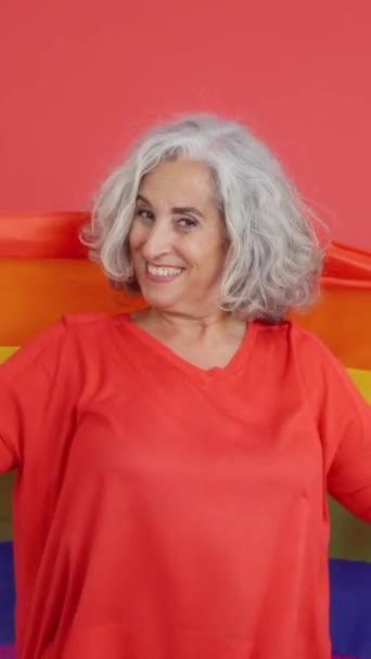 Studio Video Red Background Mature Woman Wrapped Lgbt Rainbow Flag — Αρχείο Βίντεο