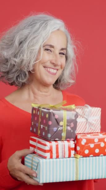 Studio Video Red Background Excited Mature Woman Receiving Many Gifts — Video
