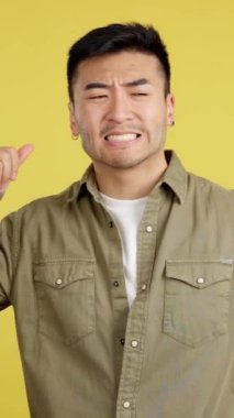 Shocked chinese man gesturing that he is forgetting something in studio with yellow background