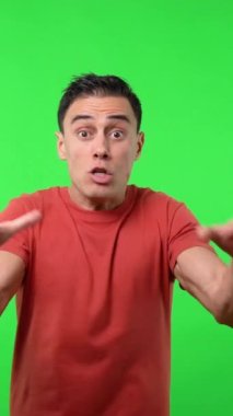 Kırmızı tişörtlü adam takımının attığı golü tutkuyla kutluyor. Krom yeşil arkaplan, orta çekim.