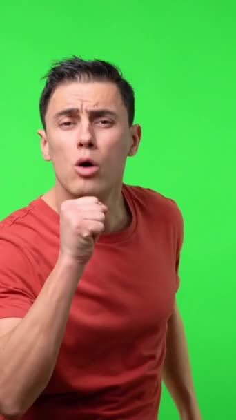 赤いシャツの男が熱烈にロマンチックなバラードを歌う クロマグリーンの背景 ミディアムショット — ストック動画