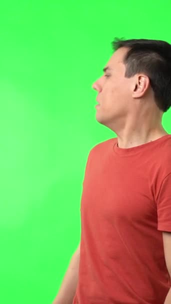 緑のクロマキーを背景に不思議な表情を浮かべながらカメラを見つめる男型のリアルタイム — ストック動画