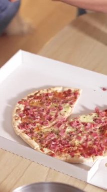 Bir dilim pizzanın yavaş çekim videosu masanın üzerindeki bir teslimat kutusuna kondu.