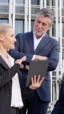 Meslektaşlarına bir şey açıklamak için tablet kullanan şık bir iş kadınının yavaş çekim videosu.