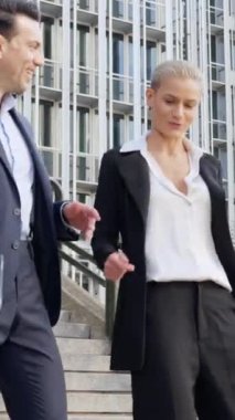 İş adamı ve kadının finans bölgesinde merdivenlerden inerken yavaş çekim videosu.