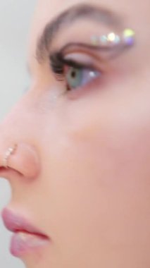 Bir kadının sahne arkasında yüzüne yapıştırıcı sürdüğü yavaş çekim videosu.