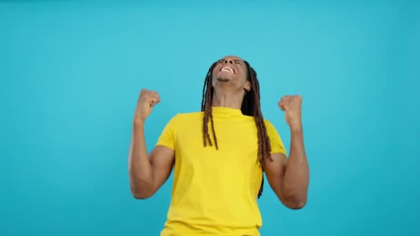 Счастливый Латиноамериканец Дредами Празднует Поднимая Кулаки Студии Синем Фоне — стоковое видео