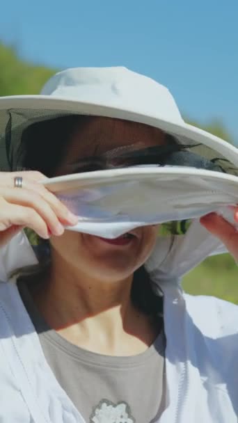 Kobieta Pszczelarz Zdejmuje Swój Kombinezon Ochronny Przed Pasieką Polu Słoneczny — Wideo stockowe