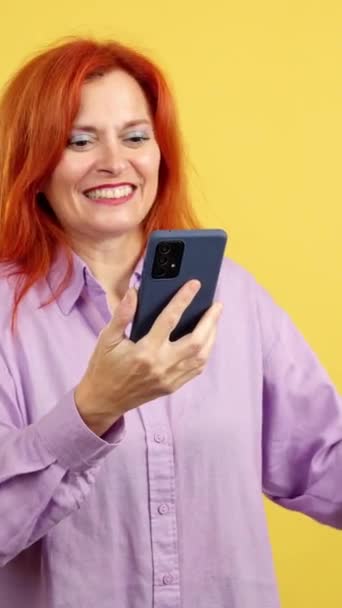 Emocionada Mujer Pelirroja Madura Celebrando Mientras Usa Teléfono Móvil Estudio — Vídeos de Stock