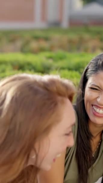 Two Women Laugh Energetically Group Friends While Sitting Outdoors — Vídeos de Stock