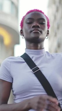 Stylish african woman crossing her arms with a serious expression in the street