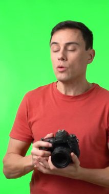 Hevesli fotoğrafçı fotoğraf çekiyor ve ekrana bakıyor. Chromakey maçının sonucundan memnun.