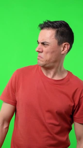 Hombre Con Camiseta Roja Mirando Lado Sospechoso Sorprendido Fondo Verde — Vídeo de stock
