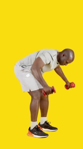 Βίντεο Στο Στούντιο Κίτρινο Φόντο Ενός Αφρικανού Κάνει Dumbbell Οπίσθια — Αρχείο Βίντεο