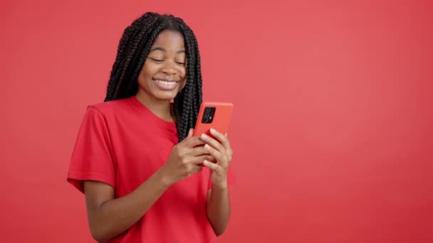 Glad Afrikansk Kvinna Ler När Använder Mobilen Studio Med Röd — Stockvideo