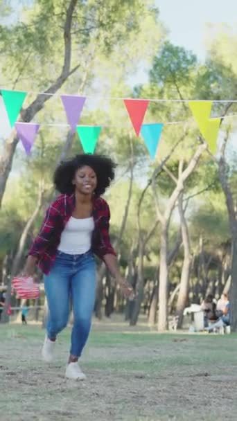 Щаслива Африканська Жінка Стрибає Подарунком Руці Парку Під Час Святкування — стокове відео