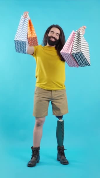 Studio Video Modrým Pozadím Šťastného Muže Protézou Nohy Holing Mnoho — Stock video