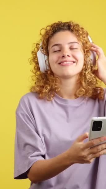 Studio Video Yellow Background Smiley Woman Curly Hair Listening Music — Stockvideo