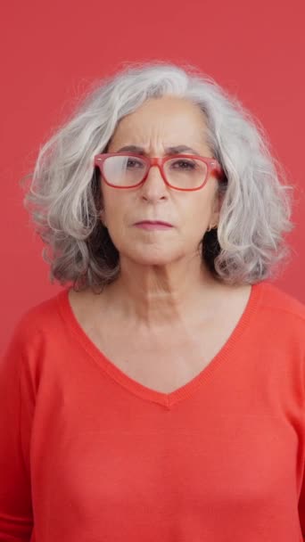 Studio Video Red Background Mature Woman Lifting Her Glasses Looking — Stockvideo