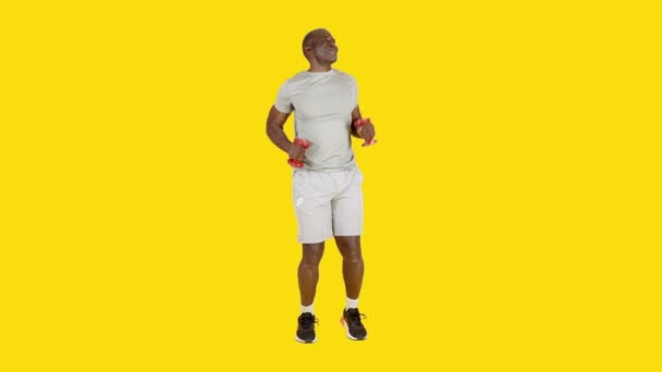 Видео Студии Жёлтым Фоном Смешного Африканского Спортсмена Танцующего Бачату Шутящего — стоковое видео