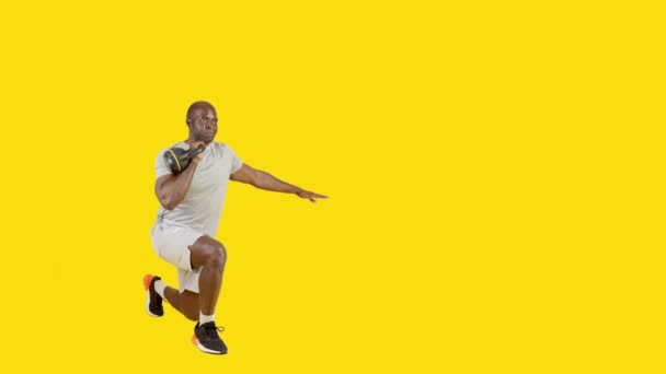 Video Studiu Žlutým Pozadím Sportovního Afrického Muže Dělá Reverzní Výpad — Stock video