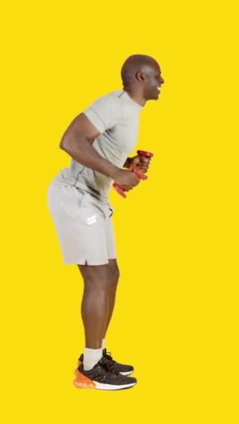 ビデオでスタジオで黄色の背景の面白いですスポーツアフリカの男踊りながら運動 — ストック動画