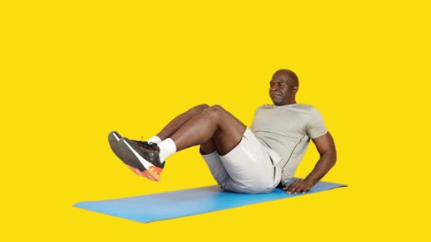 Stüdyoda Sarı Arka Planda Afrikalı Güçlü Bir Adamın Bacak Kaldırma — Stok video