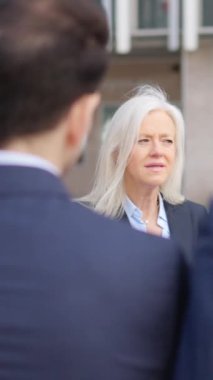 Öfkeli kıdemli bir iş kadınının çalışanlarını sokakta azarladığı yavaş çekim videosu.