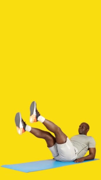 Wideo Studio Żółtym Tłem Afrykańskiego Mężczyzny Robi Siedząc Nożyczki Chrupania — Wideo stockowe