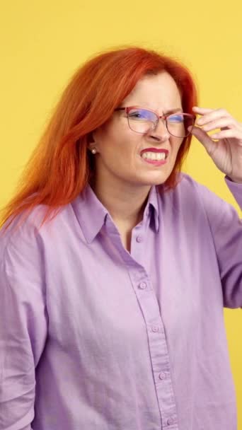 Studio Wideo Żółtym Tłem Dojrzałej Kobiety Podnoszącej Okulary Aby Zobaczyć — Wideo stockowe