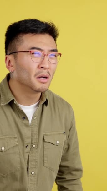 Китайська Людина Знімає Окуляри Щоб Побачити Далеко Студії Жовтим Фоном — стокове відео