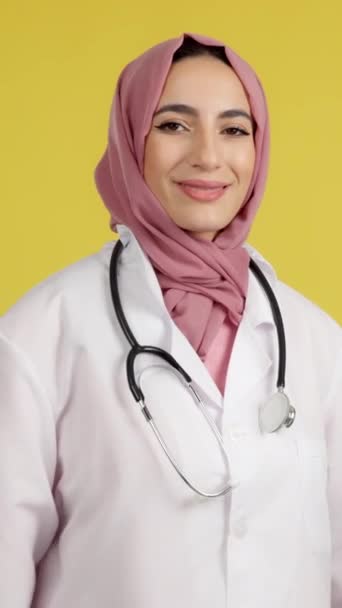 Happy Female Muslim Doctor Arms Crossed Looking Camera Studio Yellow — 图库视频影像