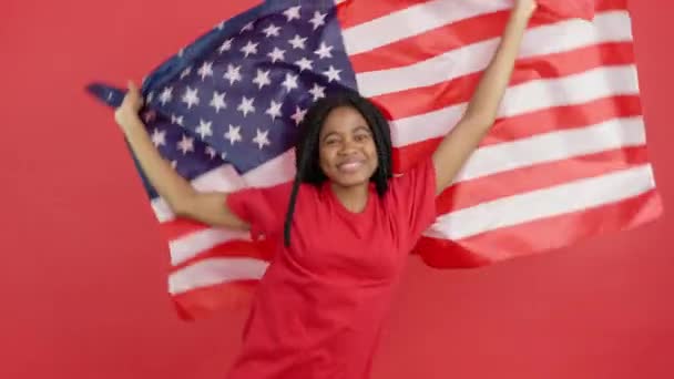 Stüdyoda Kırmızı Arka Planda Kuzey Amerika Bayrağını Göndere Çeken Mutlu — Stok video