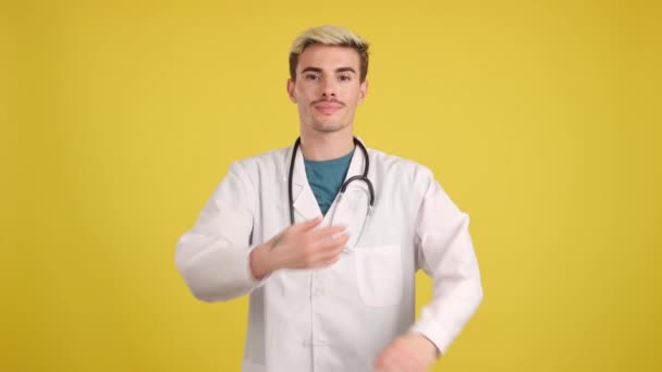 Гей Лікар Посміхаючись Камеру Стоїть Руками Схрещеними Студії Жовтим Тлом — стокове відео