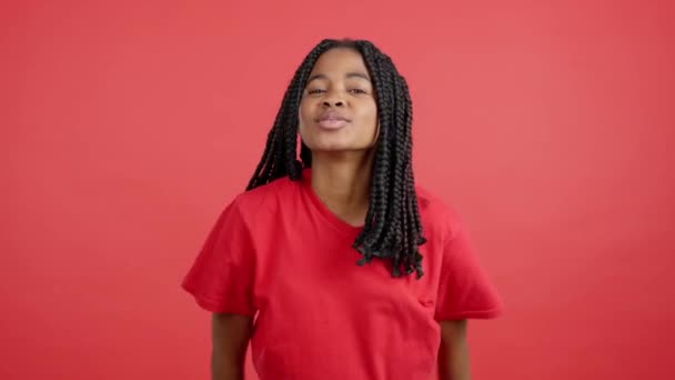 Africká Žena Foukání Polibek Očima Zavřenýma Studiu Červeným Pozadím — Stock video