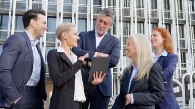 Meslektaşlarına bir şey açıklamak için tablet kullanan şık bir iş kadınının yavaş çekim videosu.