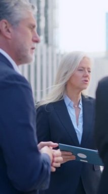 Öfkeli bir iş kadınının sokakta çalışanları azarlamasının yavaş çekim videosu.