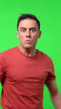 Saldırgan bir adam kavgayı arıyor yumruklarını şiddetle gösteriyor, kırmızı gömlek giyiyor. Orta boy. Krom yeşil arkaplan.