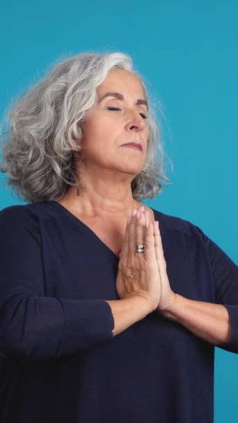 Studio Video Blue Background Mature Woman Looking While Praying Folded — Vídeo de Stock