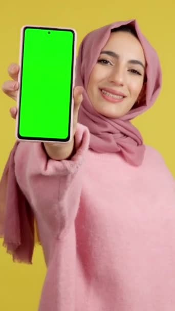 Zielony Ekran Telefonu Komórkowego Posiadanego Przez Muzułmankę Studio Żółtym Tłem — Wideo stockowe