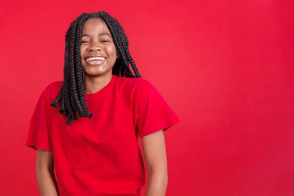 stock image Happy african woman smiling at the camera in studio with red background