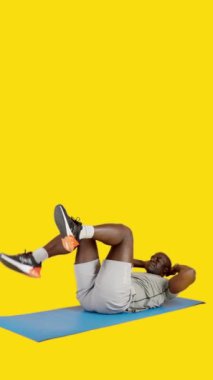 Stüdyoda Afrikalı bir adamın sarı arkaplanlı videosu var. Alternatif mekik çekiyor.