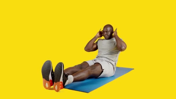 Wideo Studio Żółtym Tłem Afrykanina Robi Chrupki Przemian Nogi Rowerem — Wideo stockowe
